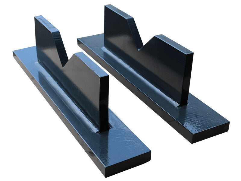 A pair of black metal prism blocks with a V-shaped top, designed to support cylindrical workpieces on a workshop press, and available on tools.de.
